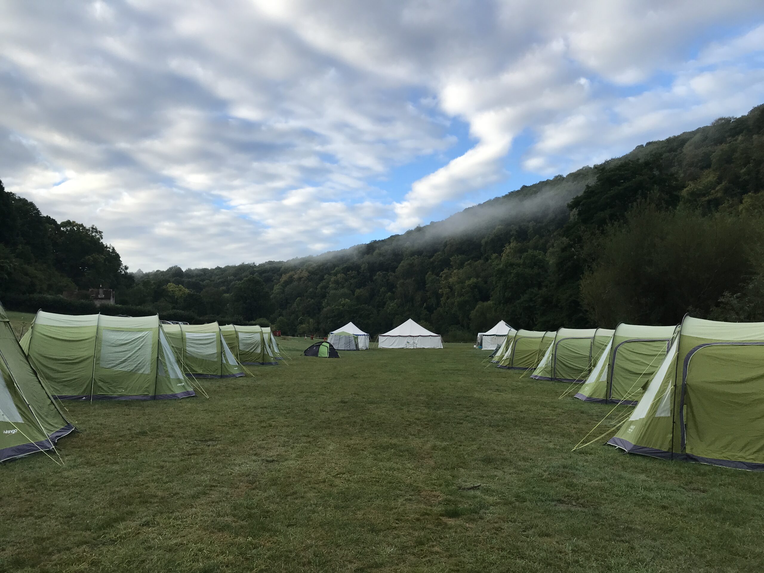 A field with rows of tents on either side and two marquees at the end.